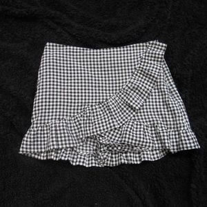 Adorable mini skirt with plaid and ruffle detail.